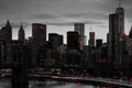 Red lights shiningÂ in black and white night time cityscape with the Brooklyn Bridge and buildings of Manhattan in New York City